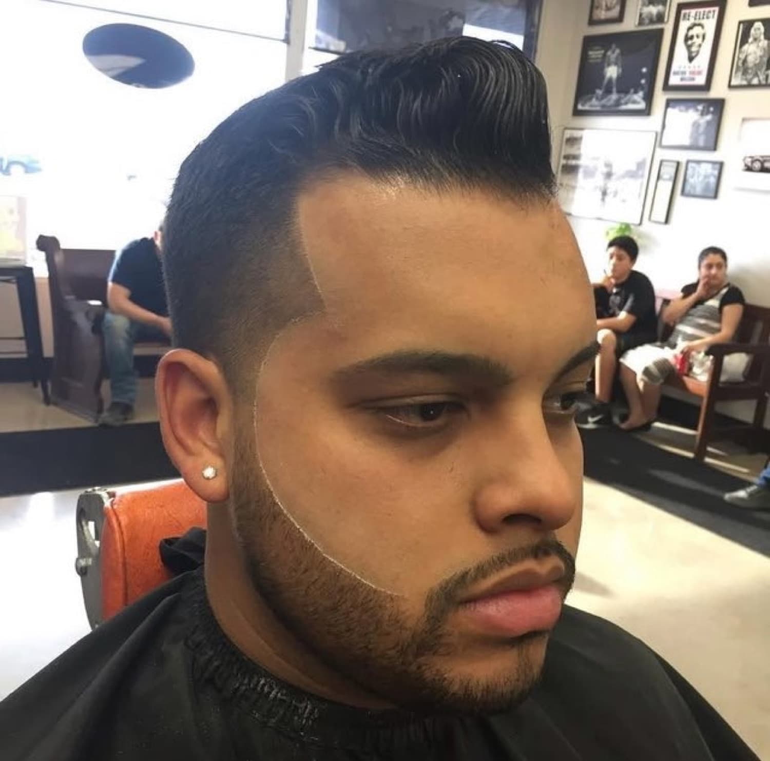 Tall pompadour quiff with razor lineup and beard work.
